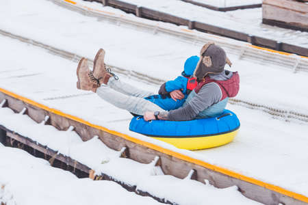 people riding snow tubing at winter park copy spaceの写真素材