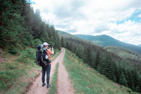 young hiker man in mountains. summer trekking path. copy space.の写真素材