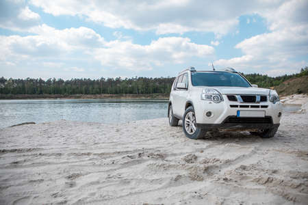 white suv car at sandy beach. road trip travel destination
