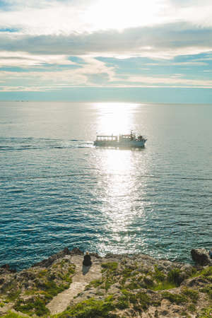 woman sitting at sea beach enjoying the beauty of sunset. copy spaceの写真素材