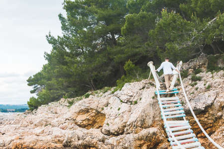 man walking by suspension bridge cross sea famous landmarkの写真素材