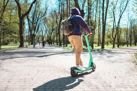man at electric kick scooter urban transport smiling springtime sunny dayの写真素材