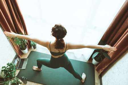 woman do yoga at home near big window healthy lifestyle