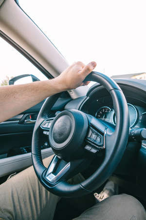 man hands on steering wheel inside view car travel sunny day