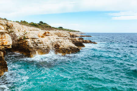 view of water with waves with rocky cliff. copy spaceの写真素材