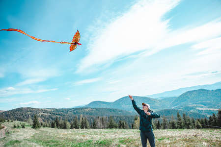 man with kids playing outdoors with kite