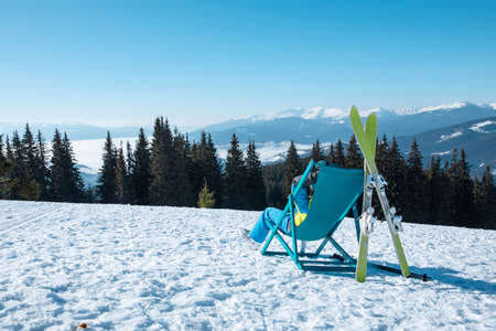 woman skier sitting in the chair with beautiful mountains panoramic view ski resort. winter vacation
