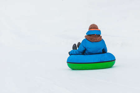 people riding snow tubing at winter park copy spaceの写真素材