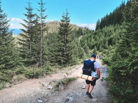 young hiker man in mountains. summer trekking path. copy space.