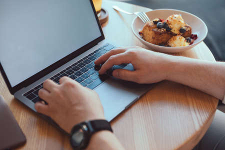 freelancer working remotely at the cafe plate with dessert copy space