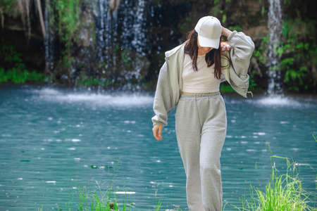woman hiker enjoying view of waterfall summertime travel concept