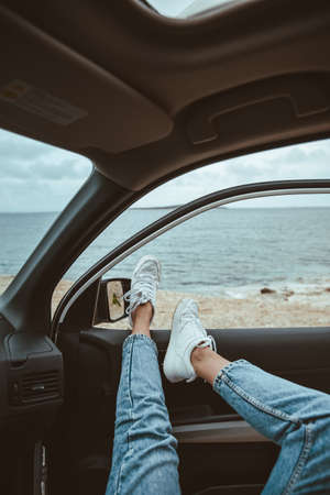 woman resting in car parked at sea beach. summer vacationの写真素材