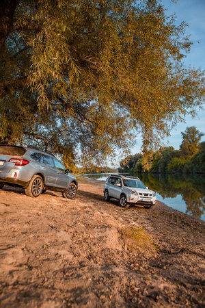 two cars parked at autumn river beach. copy space