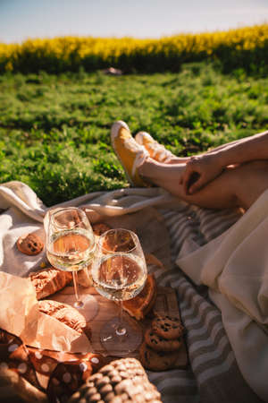woman legs on blanket having picnic on sunset food drink outdoors summertimeの写真素材