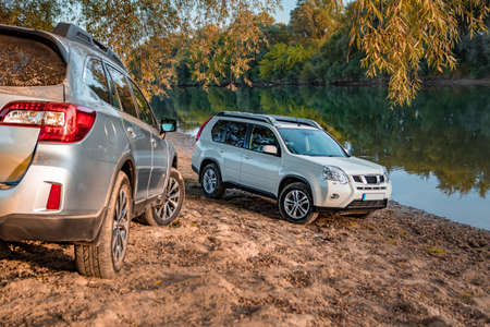 two cars parked at autumn river beach. copy space