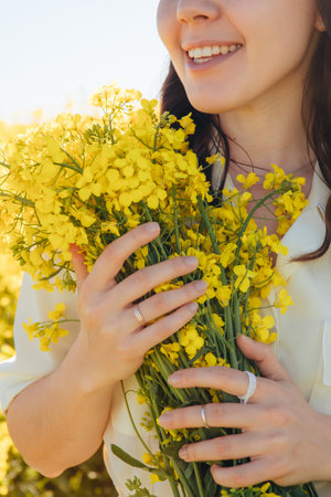 beautiful woman standing in rapeseed field summertimeの写真素材
