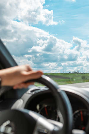 man hands on steering wheel cloudy sunny day copy space