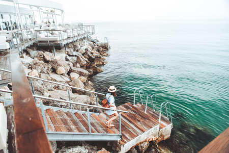 woman enjoying view of the sea walking by quay copy space summer vacationの写真素材