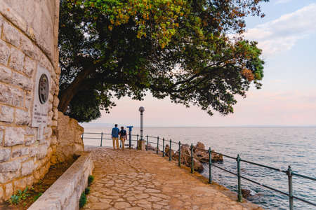 Opatija, Croatia - June 4, 2019: senior couple walking by city quay copy spaceの写真素材