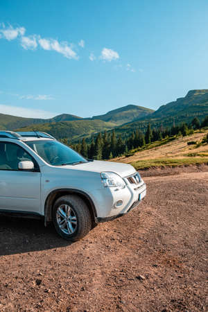 suv car on the top of ukraine carpathian mountain range summertime eveningの写真素材