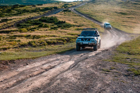 suv car on the top of ukraine carpathian mountain range summertime eveningの写真素材