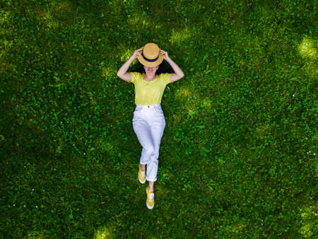 overhead view of woman laying down on green grass summertime