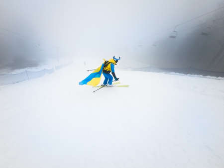 young woman skier sliding down by snowed slope winter mist weather copy space.の写真素材