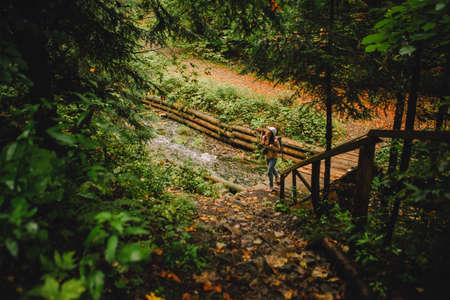 smiling hiker woman walking by autumn forest road copy spaceの写真素材