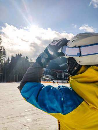 woman in ski goggles looking at sun winter resort activitiesの写真素材