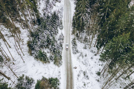 aerial view of car moving by canyon at snowed winter copy space