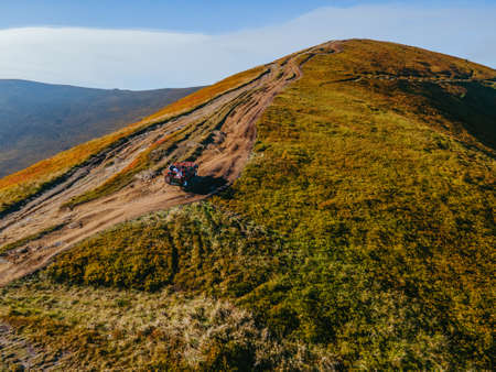 aerial view of suv off road travel climbing up by mountain hill copy space autumn season above the cloudsの写真素材
