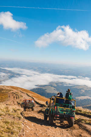 people riding suv cars at the mountain peak copy space