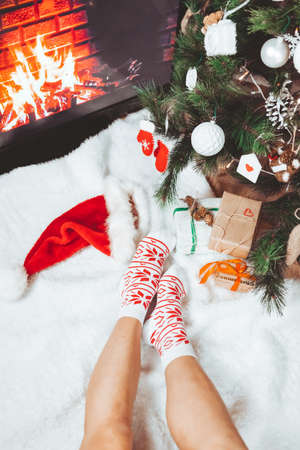 woman legs in socks near christmas tree greeting cardの写真素材