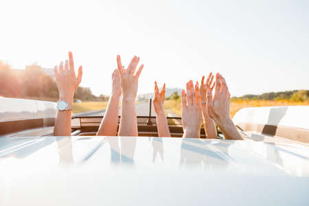 stick out hands from car sunroof happy road trip summer warm sunset