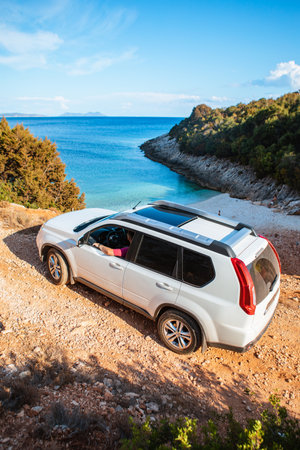 man with suv car at sea beach road trip greece lefkadaの写真素材