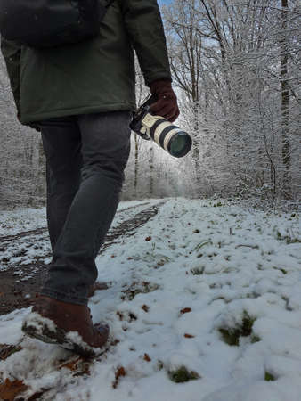 camera in man hand close up winter forest on background close upの写真素材