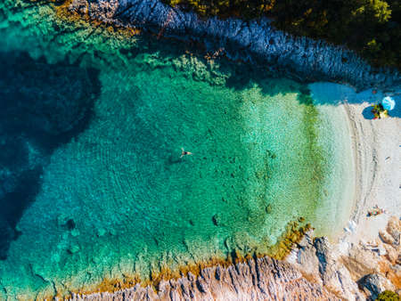 overhead view of woman floating on back in clear sea water greece vacationの写真素材