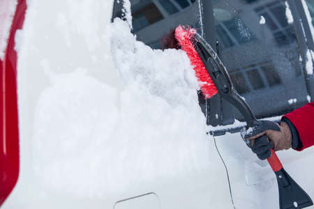 clean car of snow after blizzard winter season
