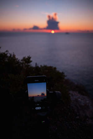 shooting sunset above the sea on the phone copy spaceの写真素材