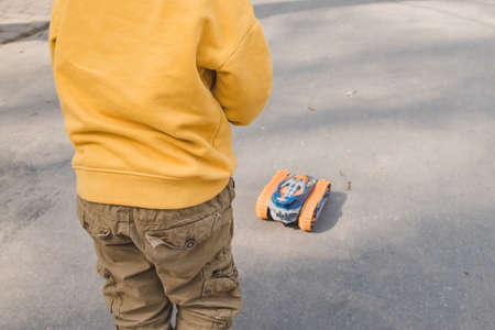 toddler boy playing outside with radio remote control car