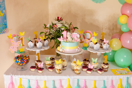 sweet counter with cakes and candies 1 year old copy space