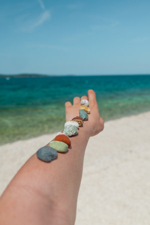 colorful rocks on woman hand at sea summer beach. copy spaceの写真素材