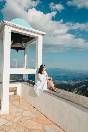 woman traveler in white dress looking of Lefkada island landscape panoramic view Greeceの写真素材
