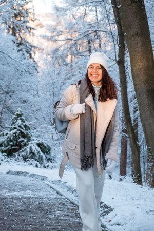 smiling woman walking by winter parkの写真素材