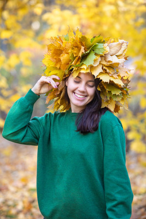 beautiful woman portrait with maple leaf wreath on the headの写真素材