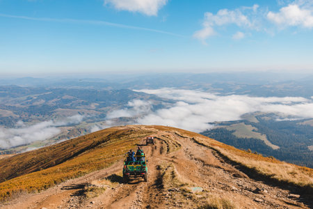 people riding suv cars at the mountain peakの写真素材