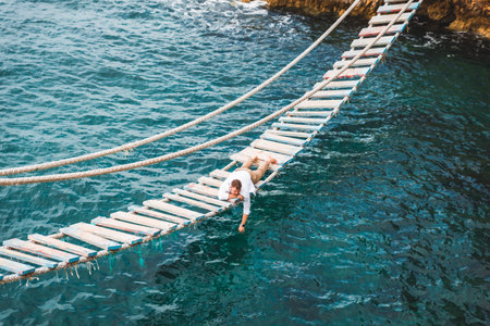 man laying at suspension bridge enjoying sea view and nature calmnessの写真素材