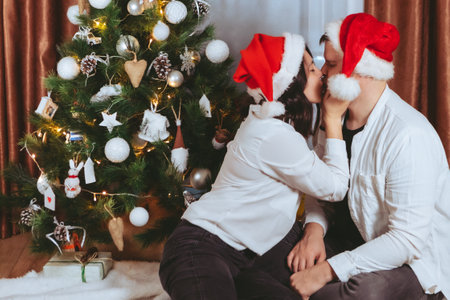 couple shooting in front of decorated christmas treeの写真素材