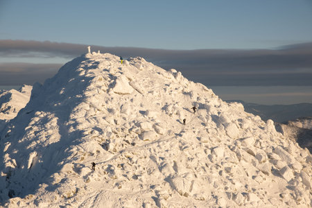 people climbing to the top of snowed mountains peakの写真素材