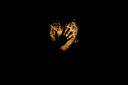 silhouette of woman hand on lighten heart symbolの写真素材